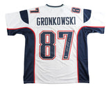 The Sports Integrity Rob Gronkowski New England signed white football jersey features navy and red accents, “GRONKOWSKI” and #87 on the back, and a silver autograph. Includes PSA/DNA hologram for authenticity.