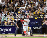 Kyle Schwarber, in a white and red Phillies uniform, swings during a game in this signed 16x20 photo from Sports Integrity. Fans in yellow and brown Padres gear fill the stadium as the catcher and umpire watch closely.