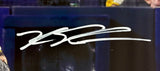 A close-up of a Kyle Schwarber signed 16x20 Philadelphia Phillies photo by Sports Integrity, featuring his autograph in white marker on a dark, blurred background.