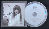 A Taylor Swift Signed Framed Tortured Poets Photo by Sports Integrity is shown alongside a CD, both mounted on black for display.