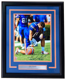 Sports Integrity Tim Tebow Signed Framed 11x14 Florida Gators Kneel Photo features Tebow in uniform holding his helmet, with an authentication hologram and a plaque: "Tim Tebow 2x NCAA National Champion.
