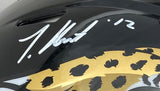 A Travis Hunter signed Jacksonville Jaguars full size authentic Speed helmet by Sports Integrity, featuring a gold jaguar design and autograph with the number 12.