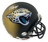 The Travis Hunter Signed Jacksonville Jaguars Dual Colored Mini Helmet by Sports Integrity features a gold and black gradient, the team's jaguar logo, and a white autograph on top.