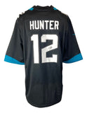 The Sports Integrity Travis Hunter Signed Jacksonville Jaguars Black Nike Game Replica Jersey features HUNTER and number 12 in white with teal accents.