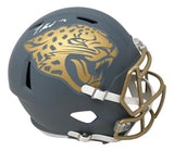 Sports Integrity Travis Hunter Signed Jacksonville Jaguars FS Slate Speed Replica Helmet features a matte gray finish, large gold jaguar logo, gold faceguard, white chin strap, autograph and #16 in white marker near the top.