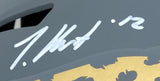 A close-up of the Travis Hunter Signed Jacksonville Jaguars FS Slate Speed Replica Helmet by Sports Integrity, showing a gold pattern on gray with his white signature and the number 12.