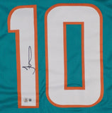 The Sports Integrity Tyreek Hill Miami Signed Teal Pro-Cut Football Jersey BAS features the number 10 outlined in orange and white, with Hill's signature on the left side of the "1" and an authentication sticker below.