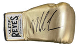 A Mike Tyson signed right-hand gold Cleto Reyes boxing glove by Sports Integrity features a visible brand label on the wrist and a bold black autograph on top.