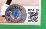 Close-up of a Beckett sticker with blue B, red "AUTHENTICATED," and QR code BD41353 on a Sports Integrity Usain Bolt Signed Framed 8x10 Olympic Track Legend Photo.