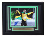 Sports Integrity Usain Bolt Signed Framed 8x10 Olympic Track Legend Photo (PSA AO93036), featuring a smiling Bolt with the Jamaica flag and plaque reading "Usain Bolt, 8x Olympic Gold Medalist.