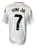 The Sports Integrity Vinicius Junior Signed Real Madrid Adidas Soccer Jersey BAS is a white jersey with black accents, featuring "VINI JR." and the number 7 on the back, plus his signature below the number.