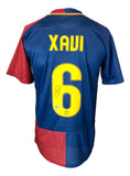 A Xavi signed Barcelona Nike 2009 UEFA Champions League soccer jersey by Sports Integrity, featuring blue and red colors with "XAVI" and number 6 in yellow on the back, autograph on the number.
