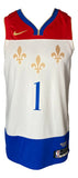The Sports Integrity Zion Williamson Signed Pelicans Nike Swingman Jersey features red, white, and blue sections, gold fleur-de-lis symbols, a blue number 1, and official Nike and NBA logos.
